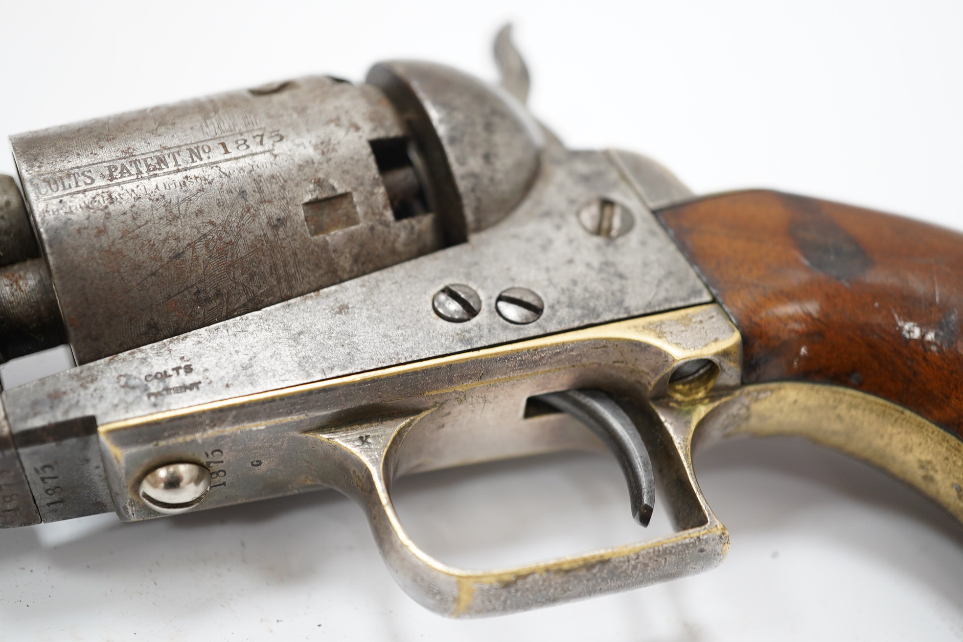 A six shot .36 Colt Navy single action percussion revolver, number 1875 (matching), regulation under lever rammer, signed barrel, roll engraved cylinder, brass mounts with traces of plating and single piece walnut grip,